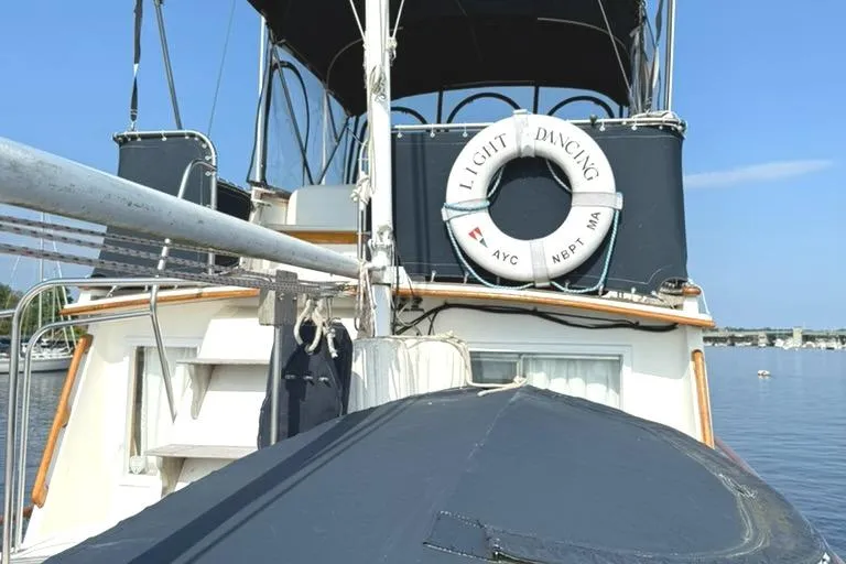 Slide: The Image of 1981 Grand Banks 36 Classic yacht with life preserver on deck, moored on calm water. - 11