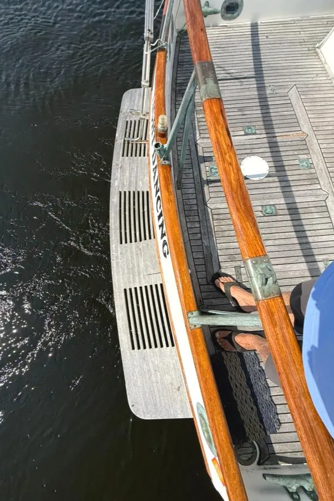 Slide: The Image of 1981 Grand Banks 36 Classic boat deck with wooden railings and water view. - 15