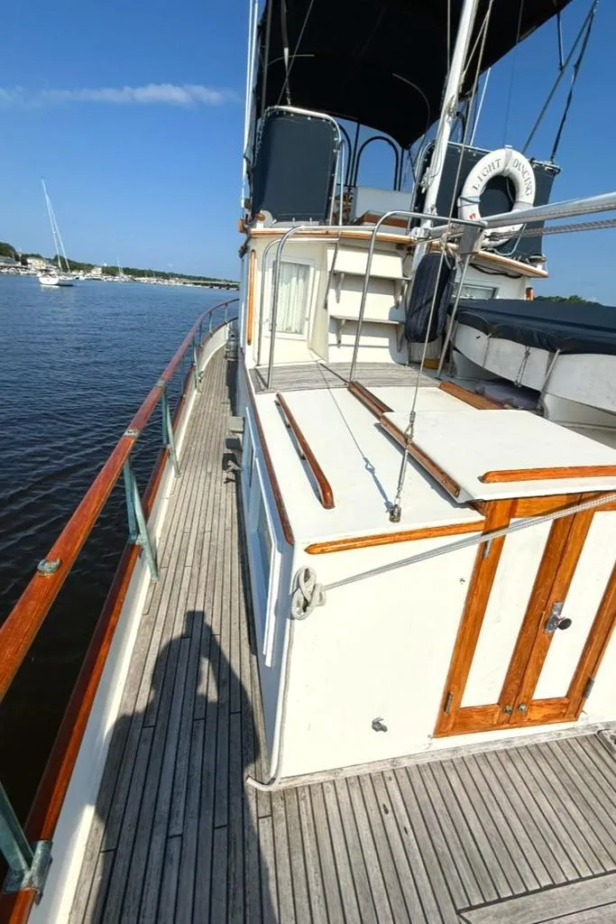 Slide: The Image of 1981 Grand Banks 36 Classic yacht deck with wooden railings on a sunny day. - 18