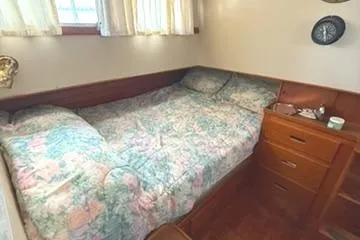 Slide: The Image of 1981 Grand Banks 36 Classic cabin with floral bedding and wooden drawers. - 22