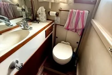 Slide: The Image of 1981 Grand Banks 36 Classic bathroom with sink, toilet, and striped towel. - 28