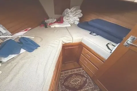 Slide: The Image of 1981 Grand Banks 36 Classic cabin with cozy bedding and wooden storage. - 35