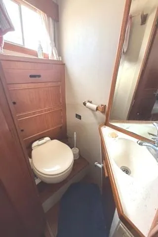 Slide: The Image of 1981 Grand Banks 36 Classic yacht bathroom with wooden cabinetry and compact sink. - 36