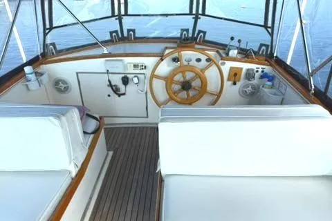 Slide: The Image of 1981 Grand Banks 36 Classic yacht helm with wooden wheel and seating. - 9