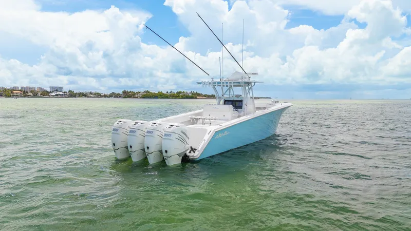 Slide: The Image of 2017 SeaHunter 39 Tournament boat with four engines on calm water under a cloudy sky. - 7