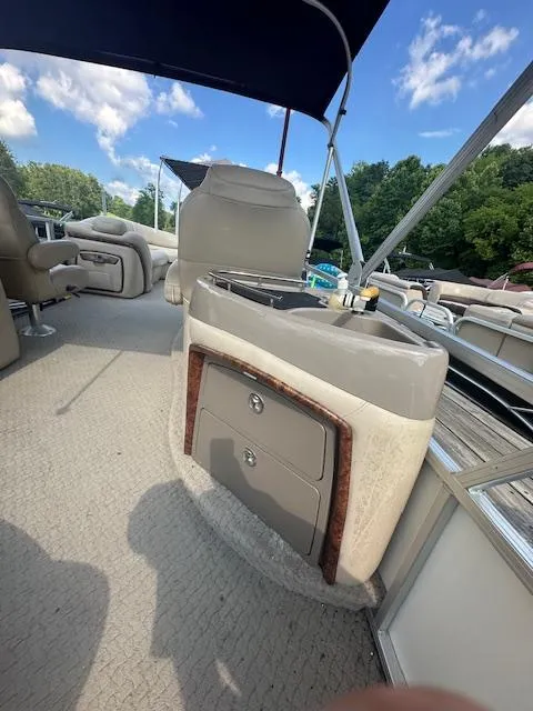 Slide: The Image of 2008 Sun Tracker PARTY BARGE 25 Regency Edition interior with seating and storage under a blue sky. - 9