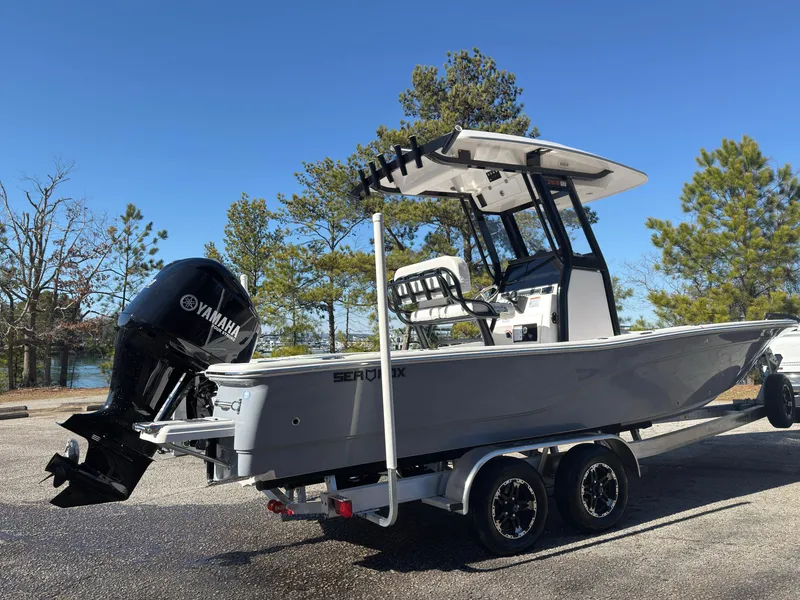 Slide: The Image of 2024 Sea Fox 251 Bay Fox boat on trailer with Yamaha engine, parked outdoors. - 3