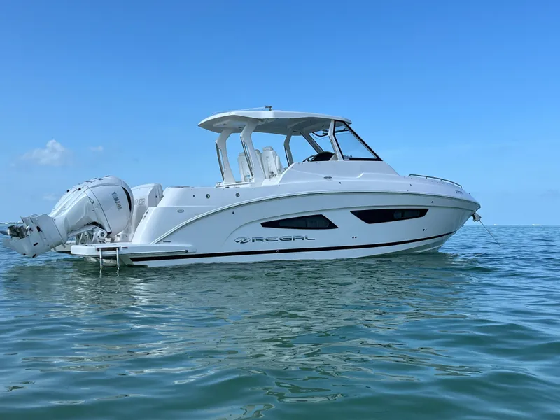 Slide: The Image of 2024 Regal 33 SAV boat docked on a sunny day, showcasing sleek design and modern features. - 0