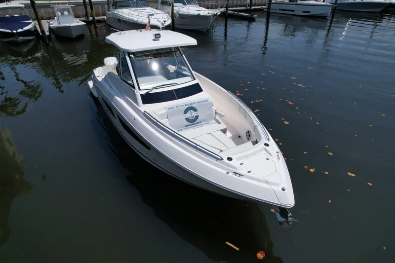 Slide: The Image of 2024 Regal 33 SAV boat docked in marina, surrounded by water and other boats. - 1