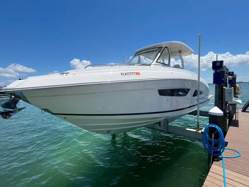 Slide: The Image of 2024 Regal 33 SAV boat cruising on a scenic waterway with palm trees. - 2