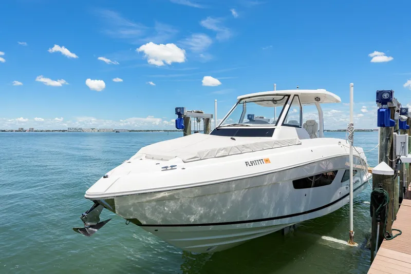 Slide: The Image of 2024 Regal 33 SAV boat with dual outboard engines on open water. - 6