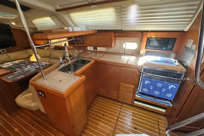 Slide: The Image of Luxurious 2002 Hunter 410 yacht interior with modern kitchen and cozy seating area. - 17