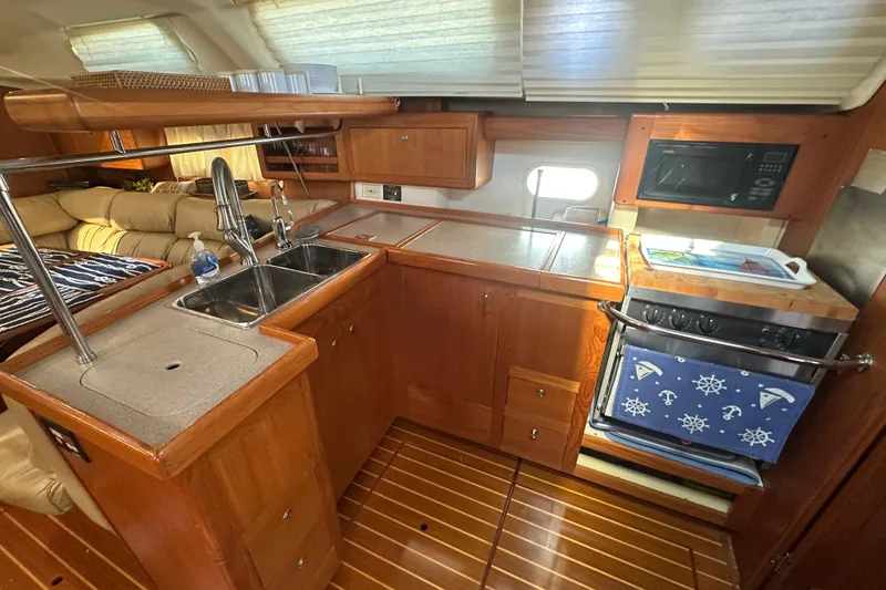 Slide: The Image of Cozy 2002 Hunter 410 yacht kitchen with wood cabinetry and modern appliances. - 18