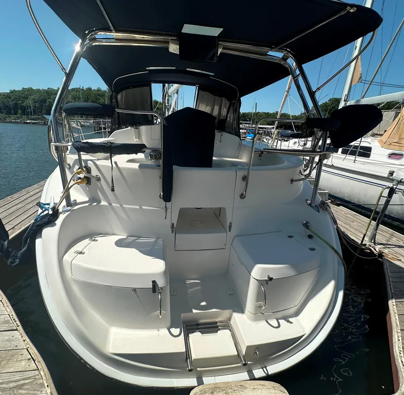 Slide: The Image of Hunter 410 sailboat from 2002 docked at marina, featuring spacious cockpit and seating. - 2