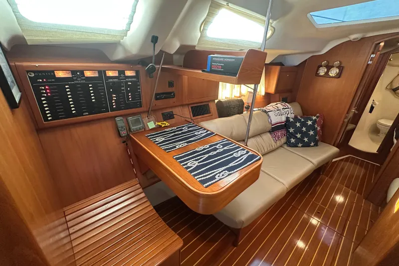 Slide: The Image of Luxurious interior of a 2002 Hunter 410 sailboat with wood paneling and cozy seating. - 21