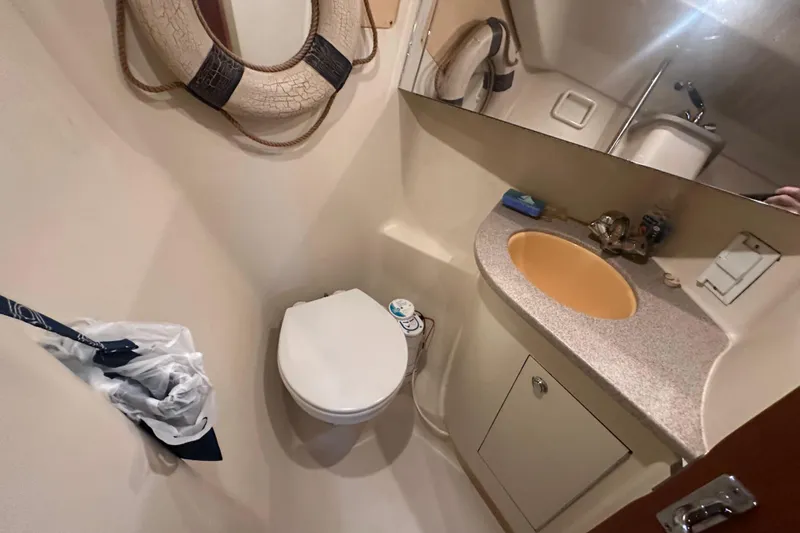 Slide: The Image of Compact bathroom in a 2002 Hunter 410 boat with toilet, sink, and mirror. - 33