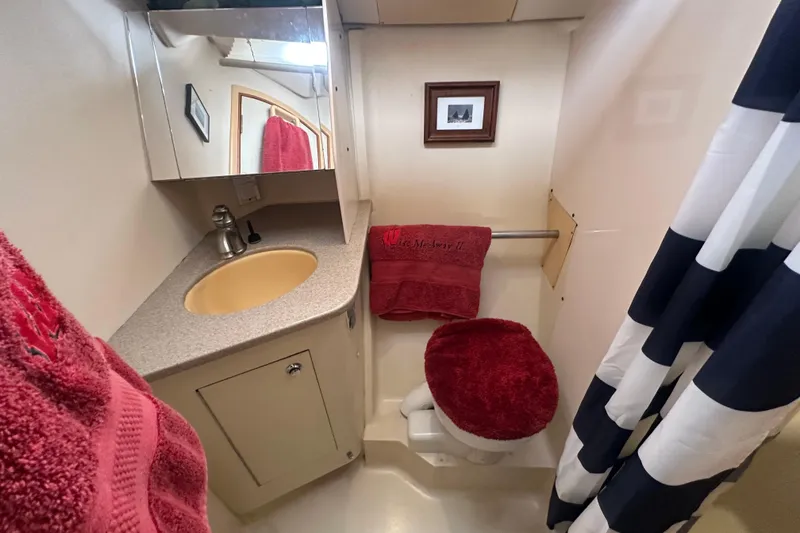 Slide: The Image of Compact bathroom in 2002 Hunter 410 boat with sink, mirror, and red accents. - 41