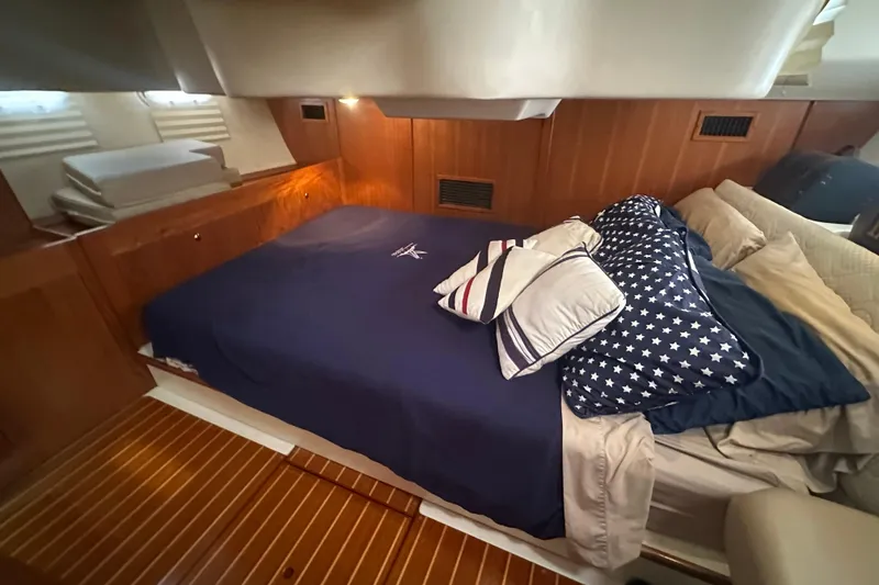 Slide: The Image of Cozy cabin interior of 2002 Hunter 410 yacht with wooden paneling and comfortable bedding. - 43