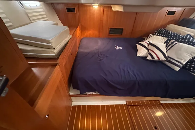 Slide: The Image of Cozy cabin interior of 2002 Hunter 410 yacht with wooden finish and nautical bedding. - 44