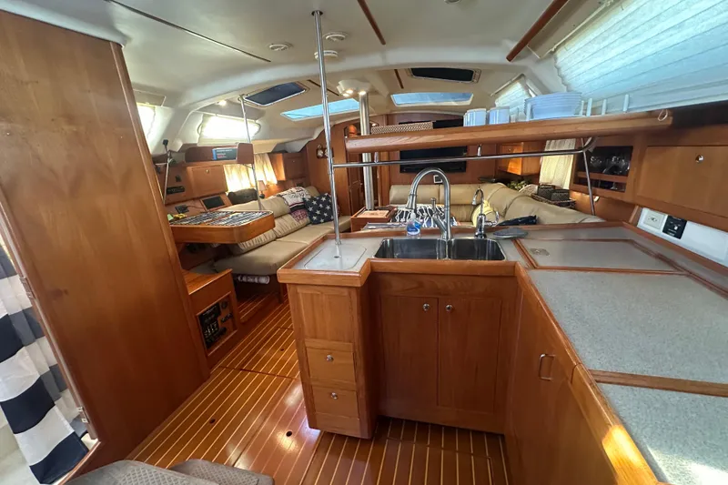 Slide: The Image of Interior of a 2002 Hunter 410 sailboat with wooden cabinetry and cozy seating area. - 48