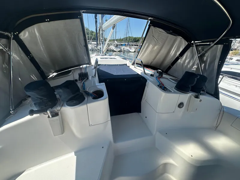 Slide: The Image of Cockpit of 2002 Hunter 410 sailboat with covered controls and marina view. - 8
