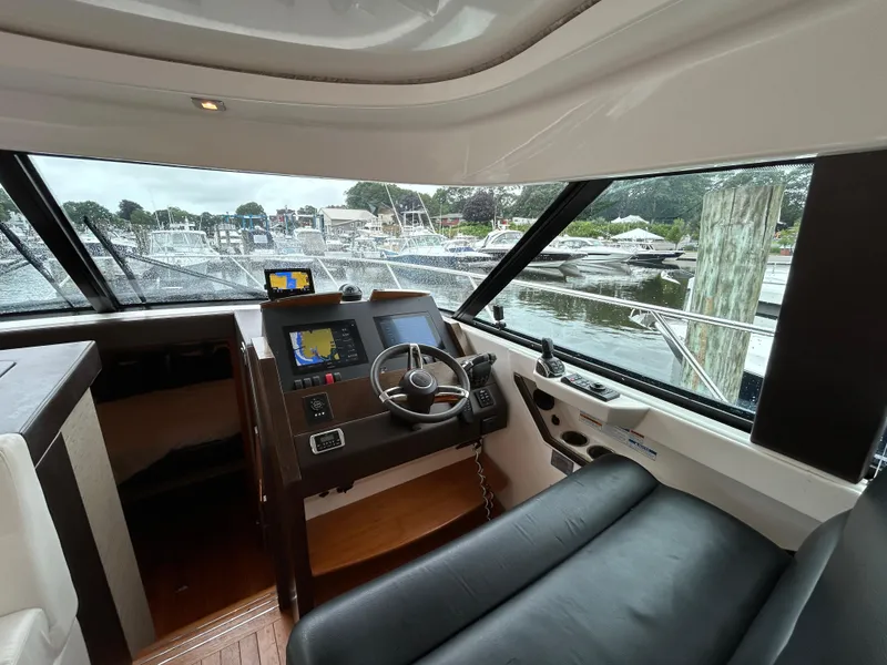 Slide: The Image of Interior view of 2015 Tiara Yachts C44 Coupe helm with marina in background. - 11