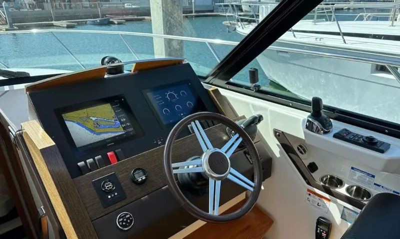 Slide: The Image of Helm of 2015 Tiara Yachts C44 Coupe with navigation screens and steering wheel. - 12