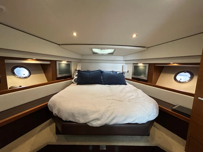 Slide: The Image of Luxurious bedroom interior of 2015 Tiara Yachts C44 Coupe with cozy bedding and porthole windows. - 16