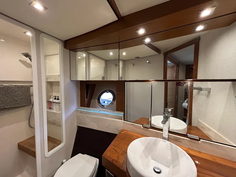 Slide: The Image of Luxurious bathroom interior of 2015 Tiara Yachts C44 Coupe with modern fixtures and porthole window. - 19
