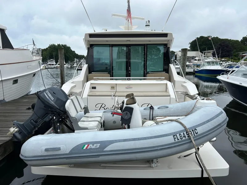 Slide: The Image of 2015 Tiara Yachts C44 Coupe docked with inflatable boat and Yamaha motor. - 2