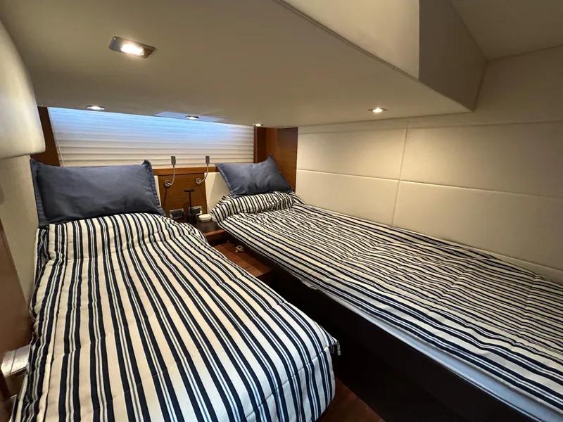 Slide: The Image of Twin beds in a 2015 Tiara Yachts C44 Coupe cabin with striped bedding. - 20