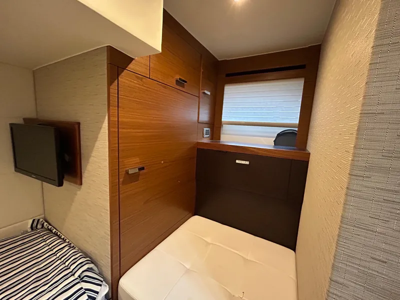 Slide: The Image of 2015 Tiara Yachts C44 Coupe interior cabin with wood paneling and cozy seating. - 21