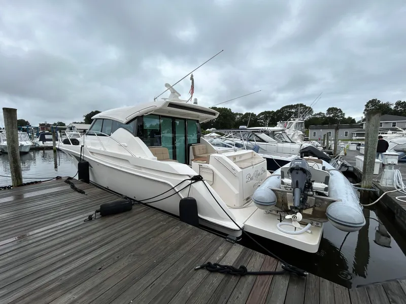 Slide: The Image of 2015 Tiara Yachts C44 Coupe docked at marina with inflatable boat. - 3