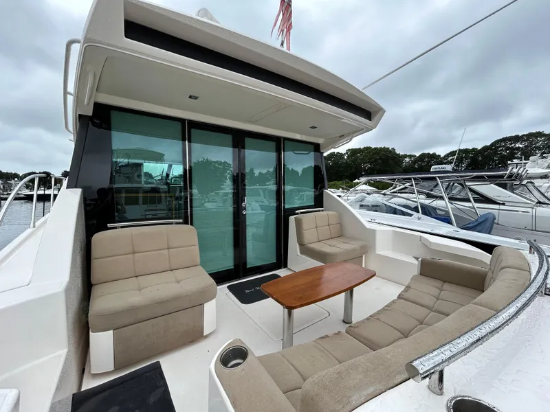 Slide: The Image of 2015 Tiara Yachts C44 Coupe with outdoor seating and table, docked at marina. - 4