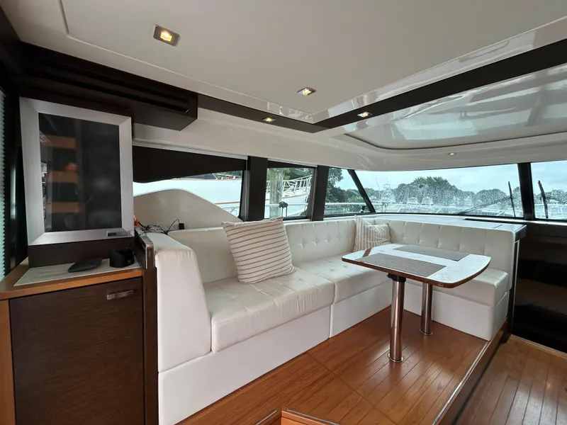 Slide: The Image of Luxurious interior of 2015 Tiara Yachts C44 Coupe with white seating and wooden accents. - 8