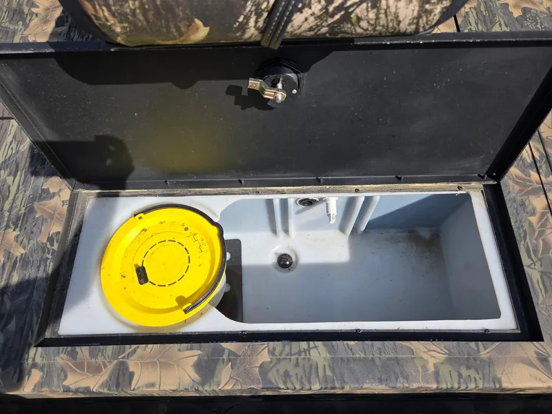 Slide: The Image of Open storage compartment in 2018 Lowe 175 Stinger boat with yellow lid inside. - 11