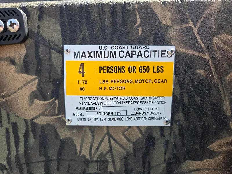 Slide: The Image of 2018 Lowe 175 Stinger capacity plate, 4 persons or 650 lbs, camouflage background. - 13