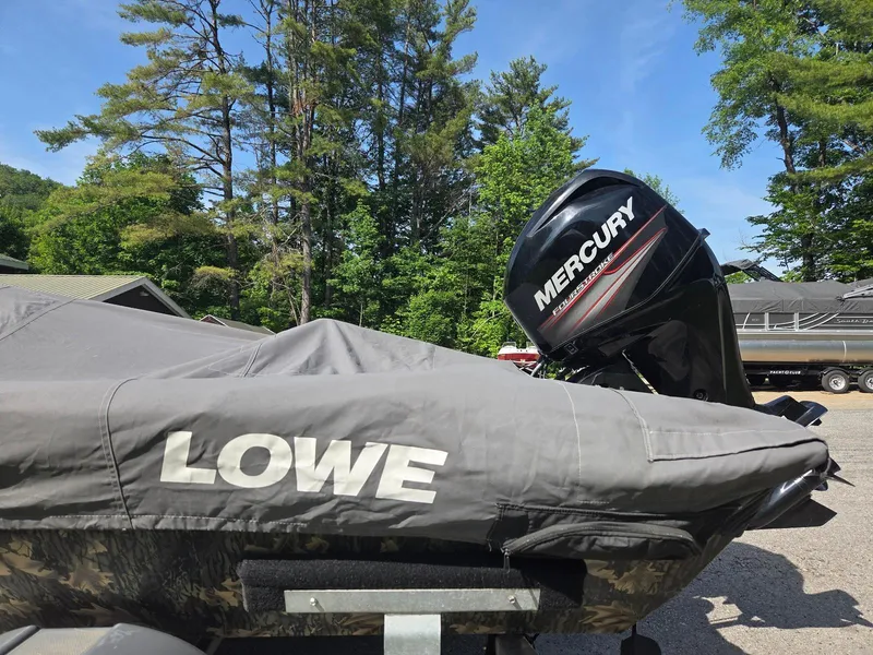 Slide: The Image of 2018 Lowe 175 Stinger boat with Mercury engine, covered and parked outdoors. - 19