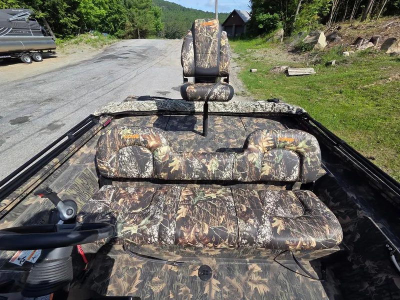 Slide: The Image of 2018 Lowe 175 Stinger boat with camouflage seating, parked on a rural road. - 5