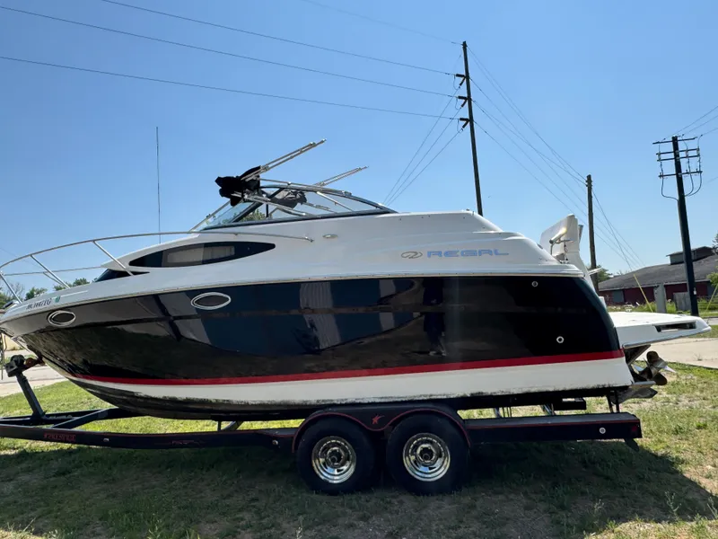 Slide: The Image of 2006 Regal 2565 Window Express boat on trailer, parked outdoors under clear sky. - 1