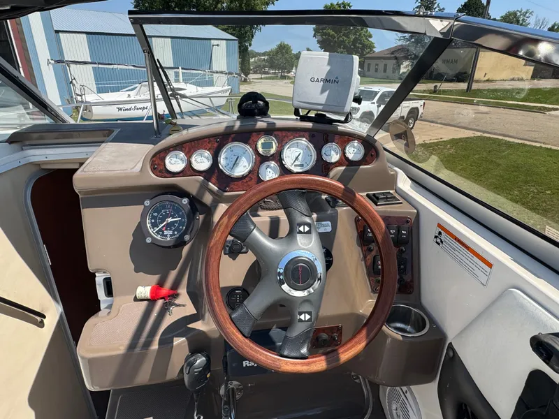 Slide: The Image of 2006 Regal 2565 Window Express boat dashboard with steering wheel and Garmin GPS. - 13