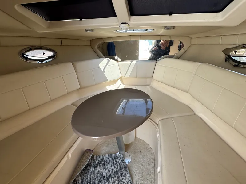 Slide: The Image of Interior of 2006 Regal 2565 Window Express boat with beige seating and table. - 19