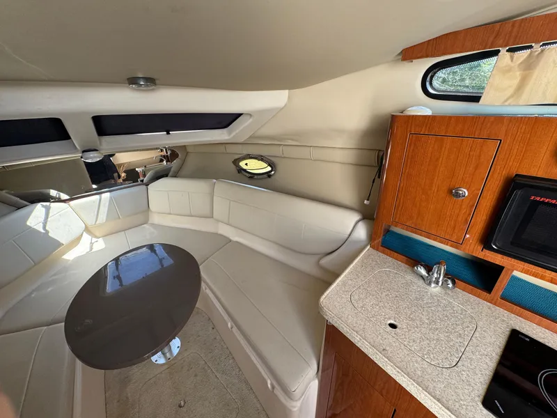 Slide: The Image of Interior of 2006 Regal 2565 Window Express boat with seating, table, and kitchenette. - 20
