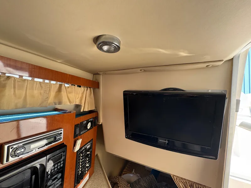 Slide: The Image of Interior of 2006 Regal 2565 Window Express boat with TV and control panel. - 23