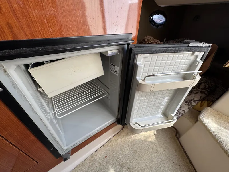Slide: The Image of Open mini fridge inside 2006 Regal 2565 Window Express boat cabin. - 24