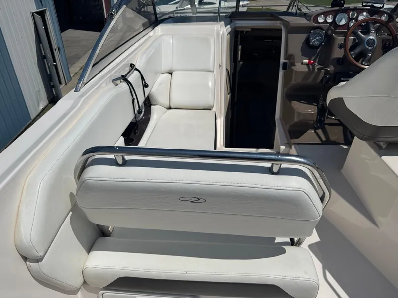 Slide: The Image of 2006 Regal 2565 Window Express boat interior with white seating and steering console. - 8