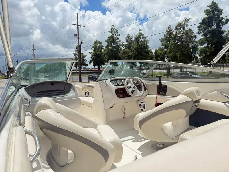 Slide: The Image of 2007 Chaparral 190 SSi boat interior with white seating and dashboard under cloudy sky. - 14