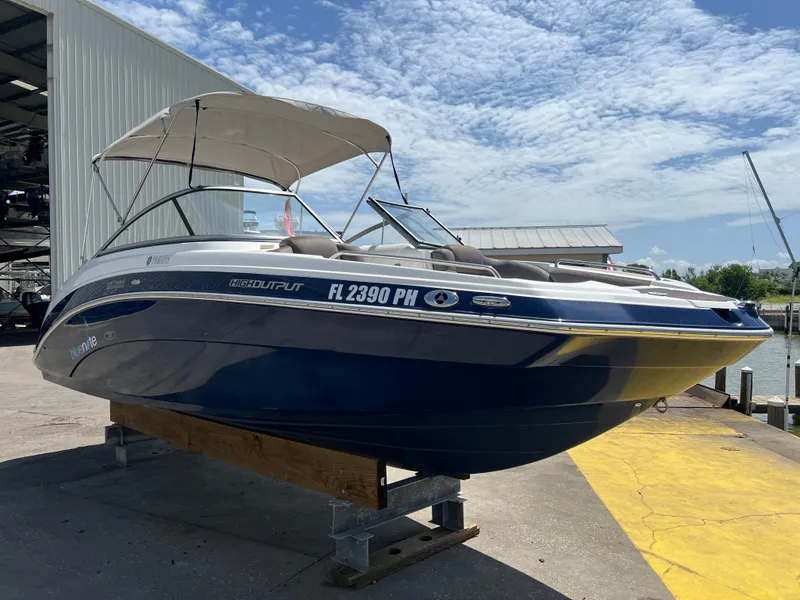 Slide: The Image of 2012 Yamaha Boats 242 Limited on display at a marina, featuring a sleek blue design. - 3