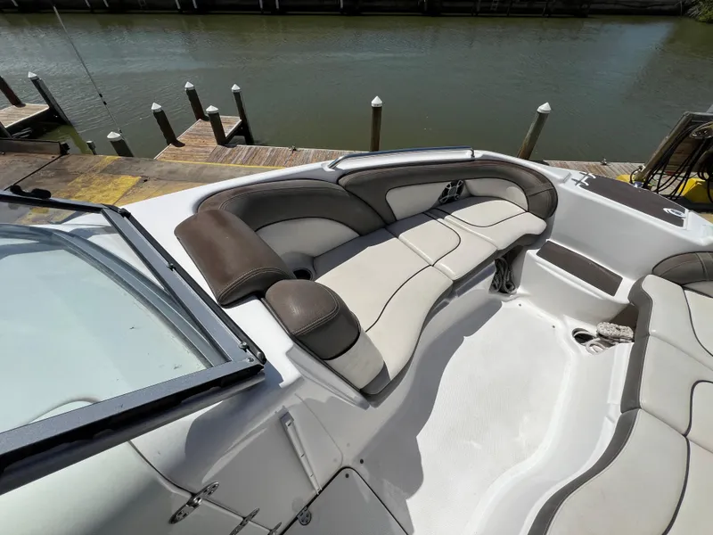 Slide: The Image of 2012 Yamaha Boats 242 Limited interior with cushioned seating at dockside. - 6