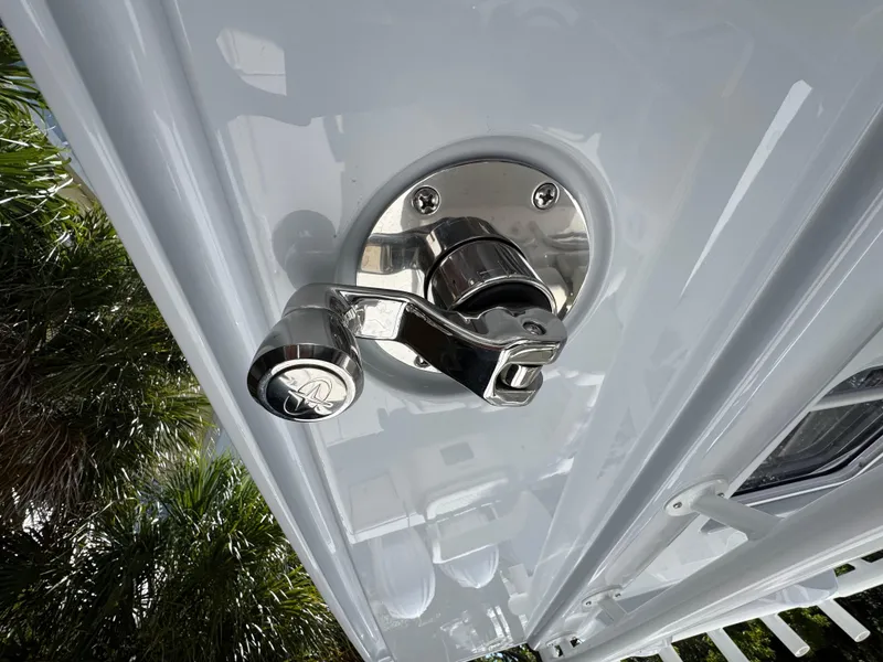 Slide: The Image of Chrome latch on 2025 Jupiter 380LS boat, surrounded by palm trees. - 11
